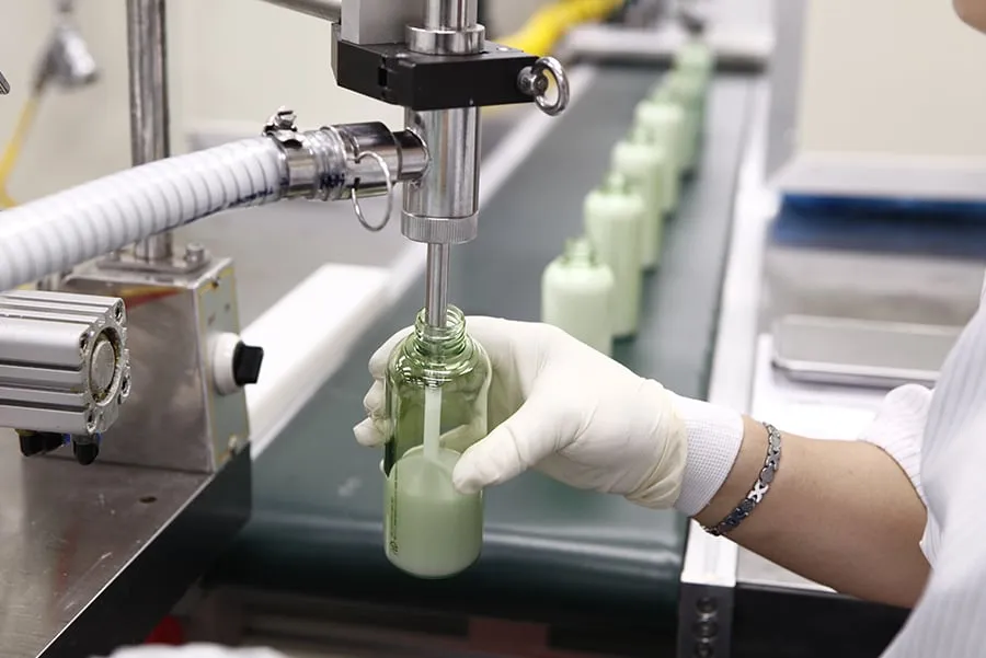 Bottles being filled on a cosmetic filling line