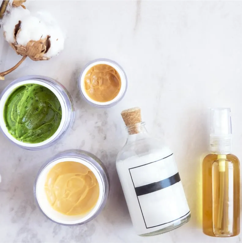 Open jars of cream and clay masks on a table