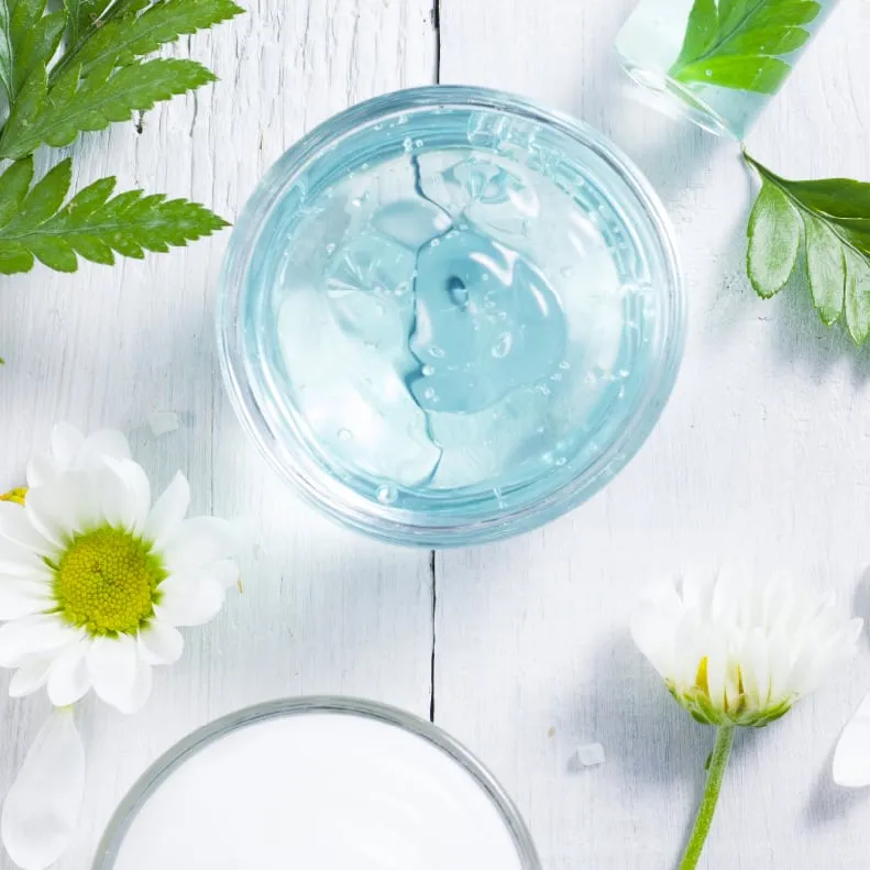 Bowls of gel and cream with fresh flowers
