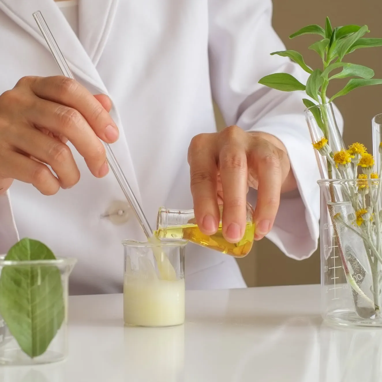 Pouring a botanical extract into a beaker in the formulation laboratory