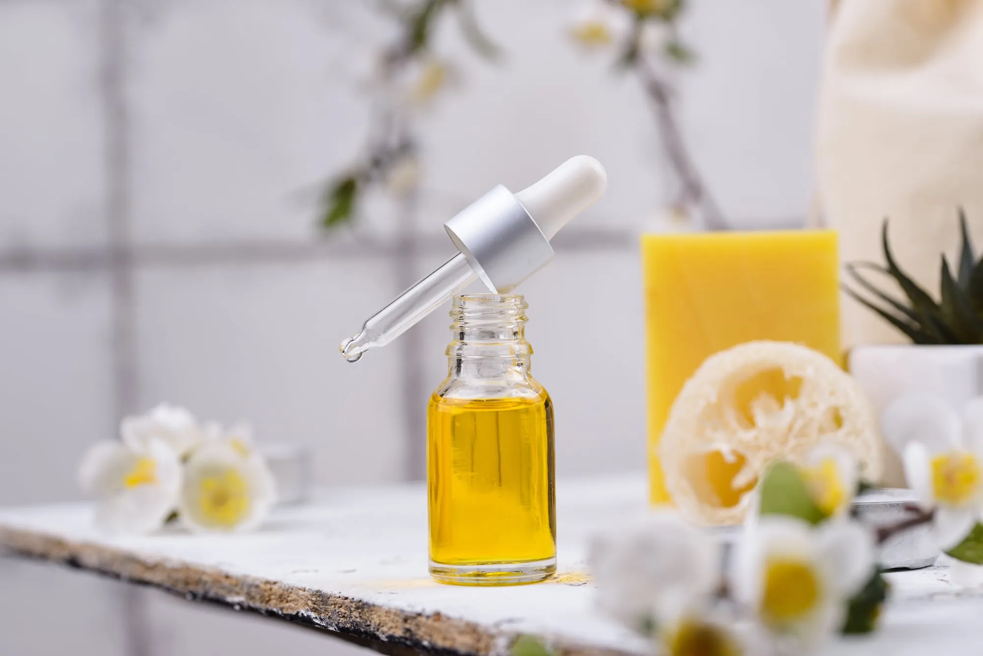 Glass dropper bottle of serum on marble